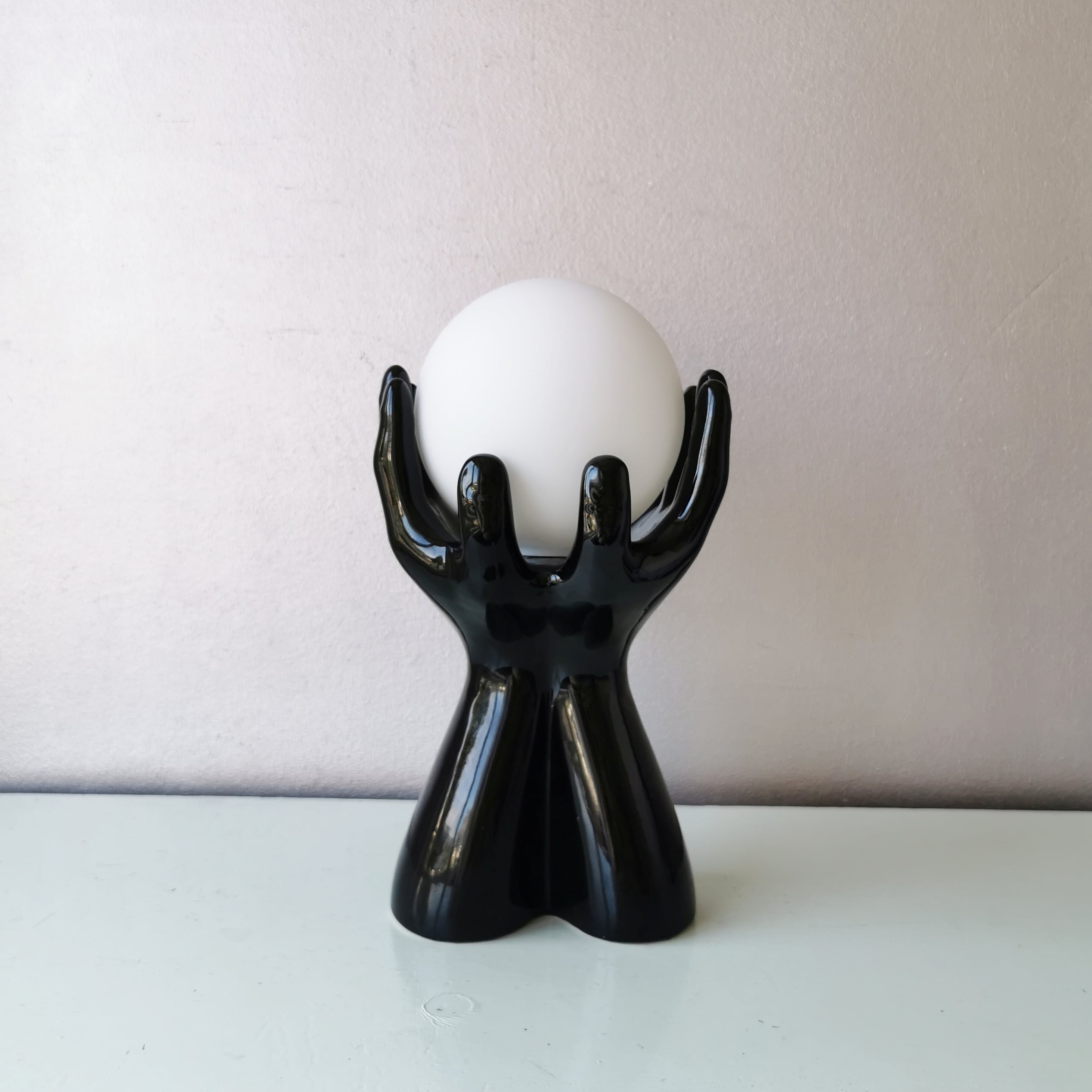 Italian design ceramic table lamp, two hands and glass shade.