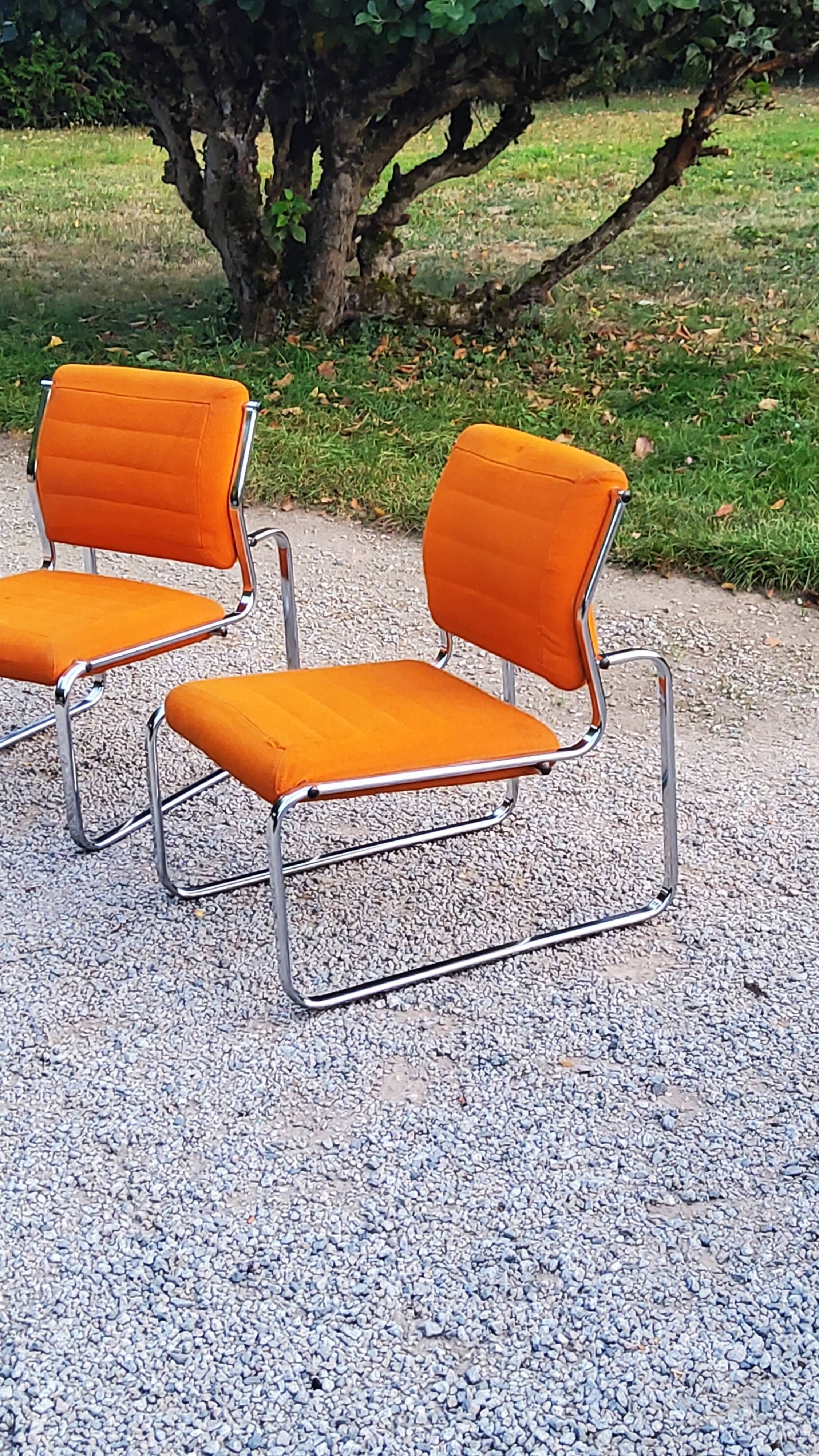Pair of designer armchairs in orange fabrics and chrome tubes from the 70s