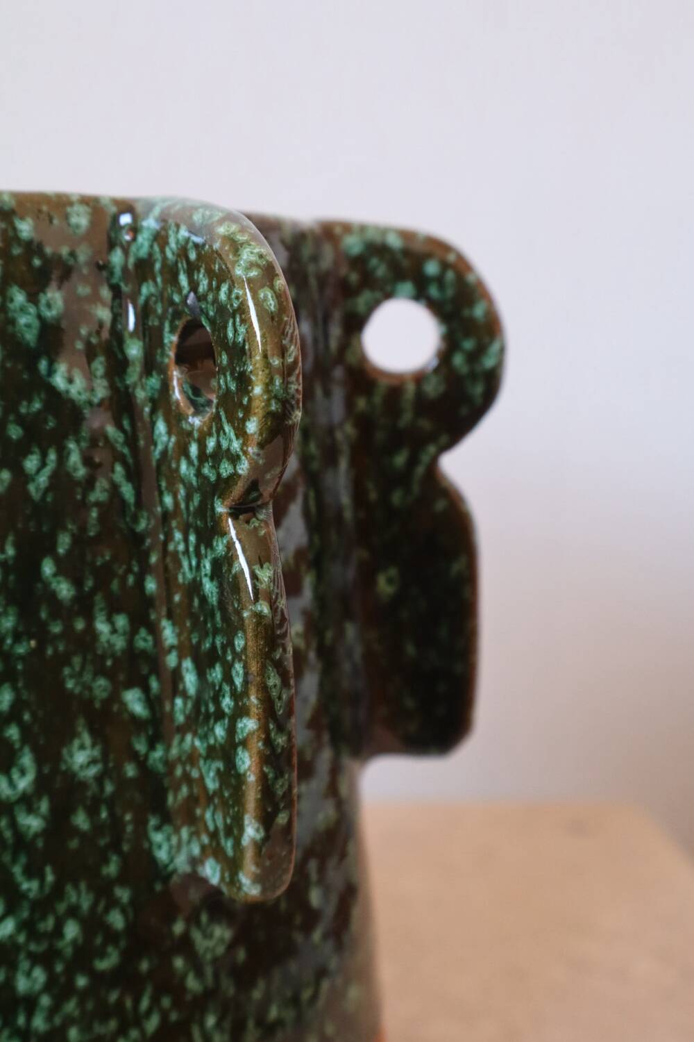 Sculptural ceramic vase with dark green glaze and shimmering highlights