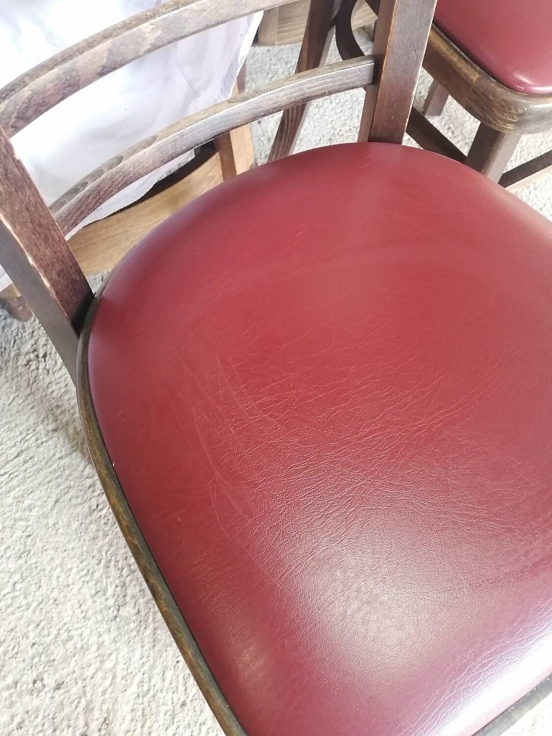 Set of 19 vintage wooden bistro chairs with red faux leather.
