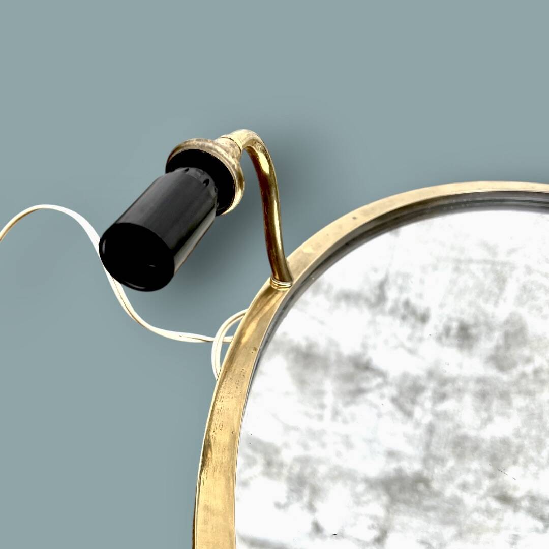 Oval wall mirror in gilded brass with double sconces – 1950s/60s