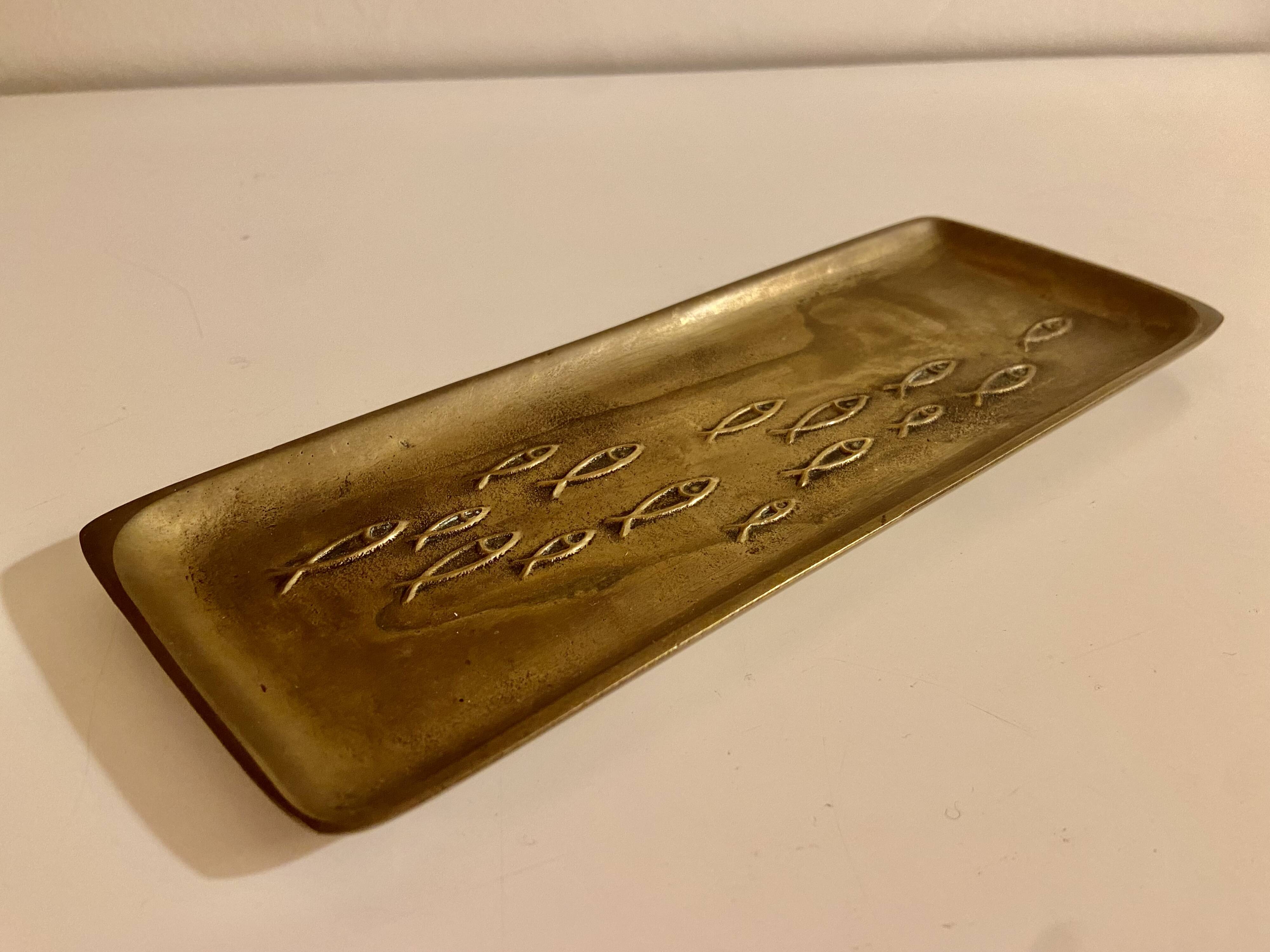 Bronze pocket emptier with fish decoration.