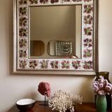 Large square ceramic mirror with floral decoration.