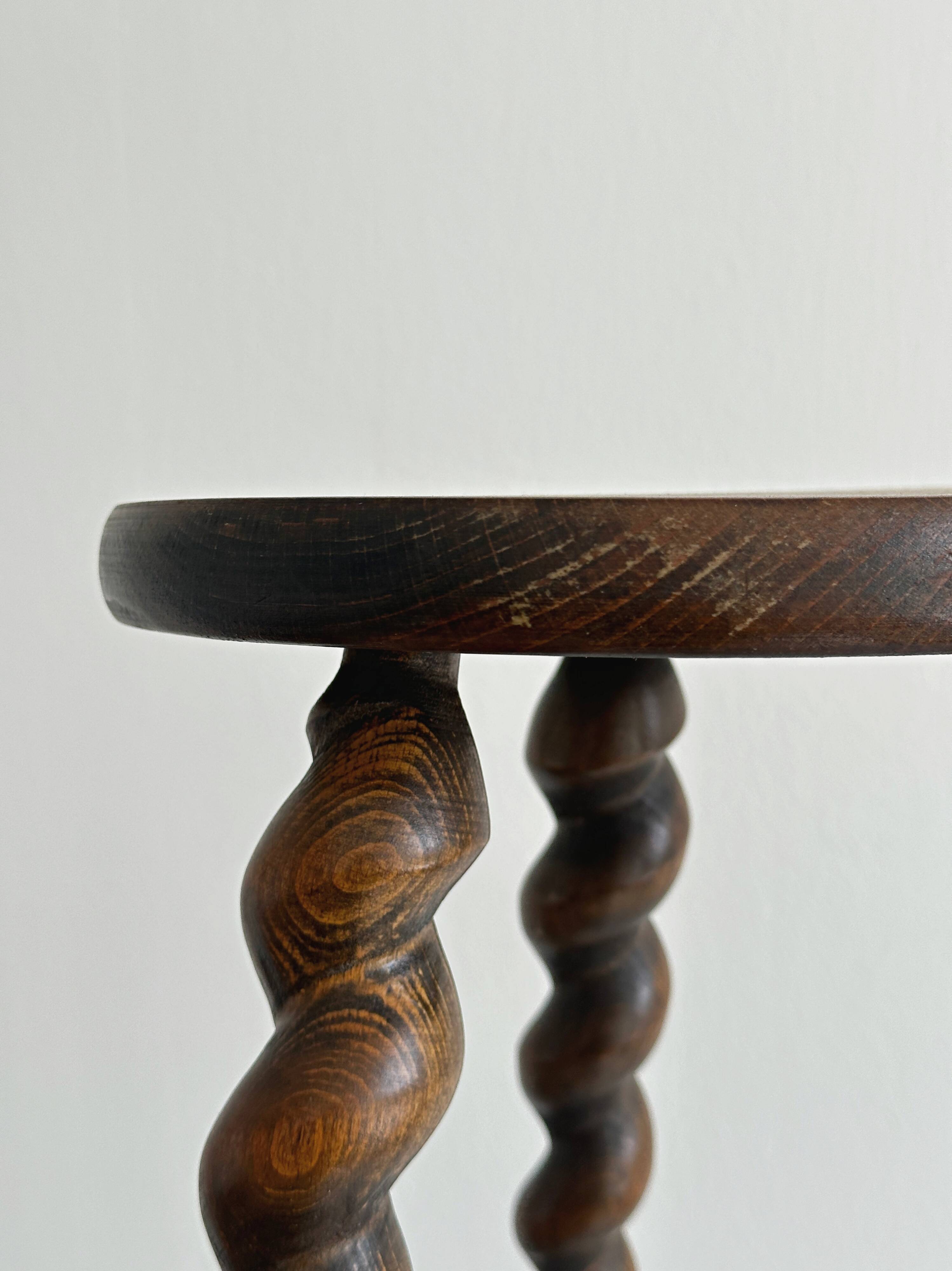 Small antique tripod stool in dark wood.