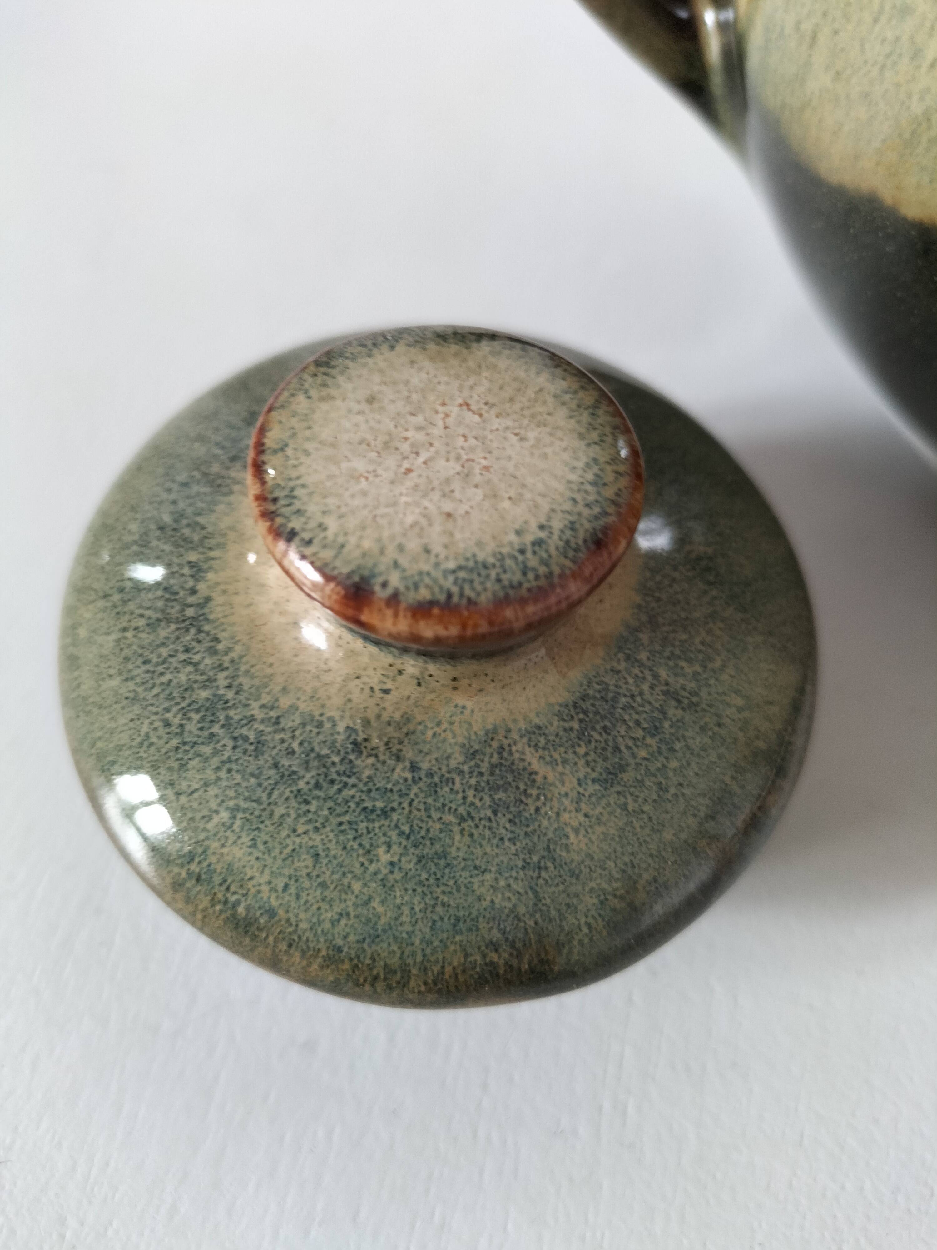Vintage ceramic teapot with a flame design.