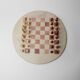 Vintage 1980s round chess set in marble, with a beige and pink marble board and wooden pieces.