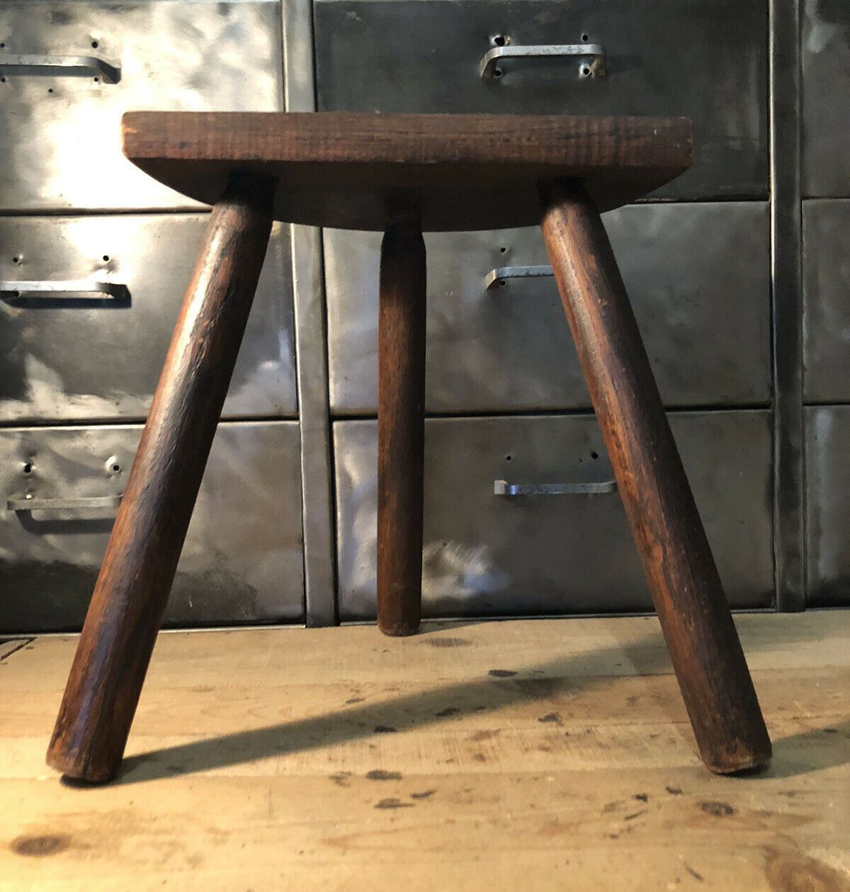 Wooden milking stool on tripod base