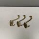 Three old and beautiful brass hooks with decorative motifs