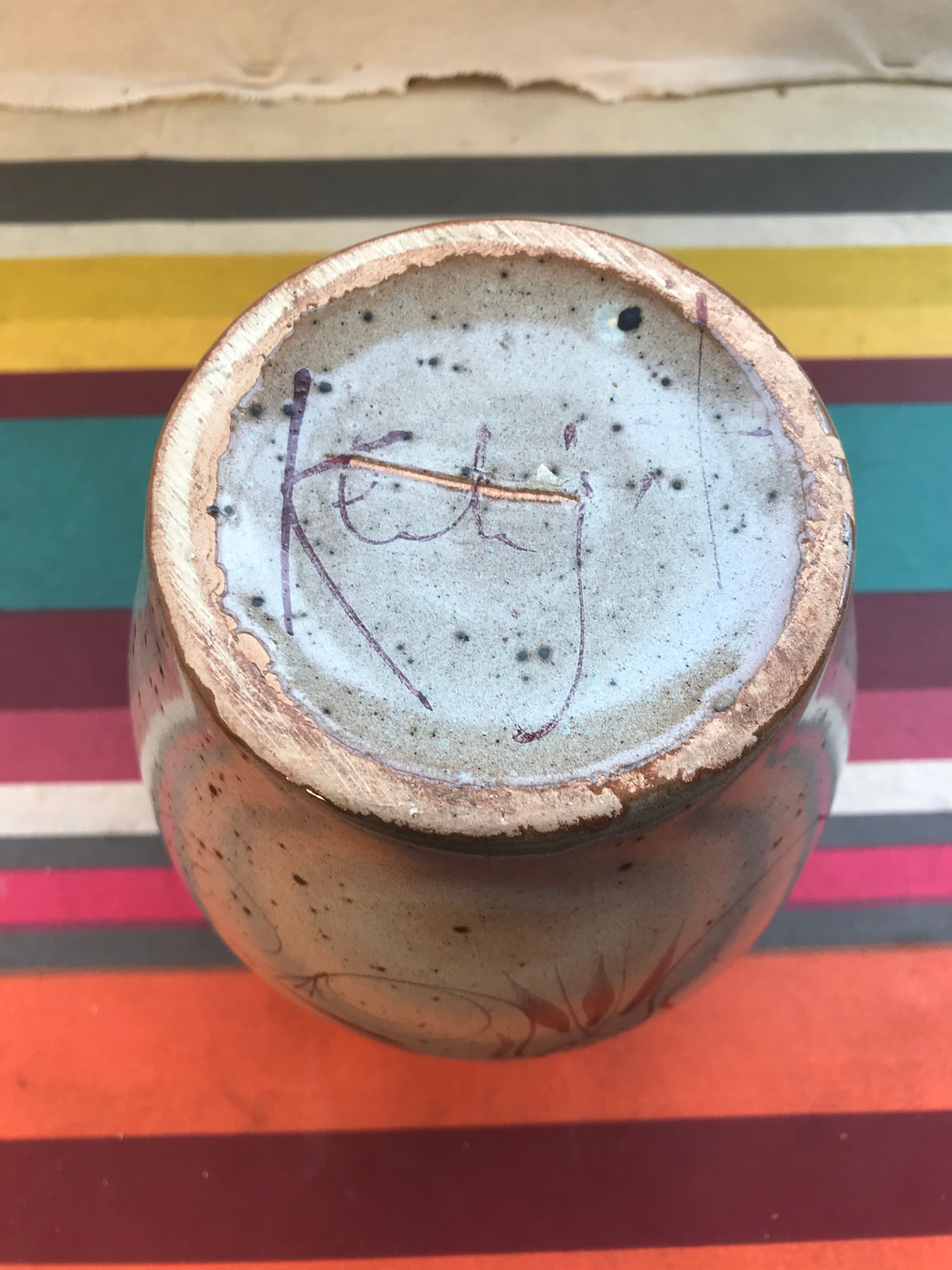 Old gray pitcher with black drawings and vintage stamped handle