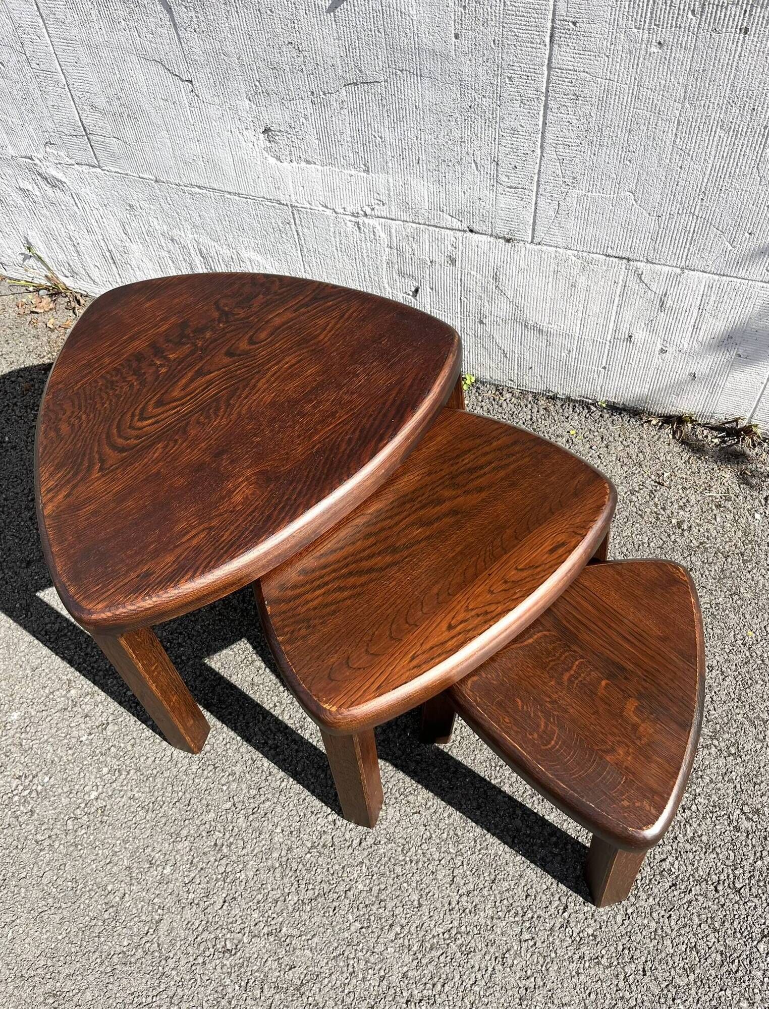 Nested tripod tables made of solid wood, in a modernist brutalist style.