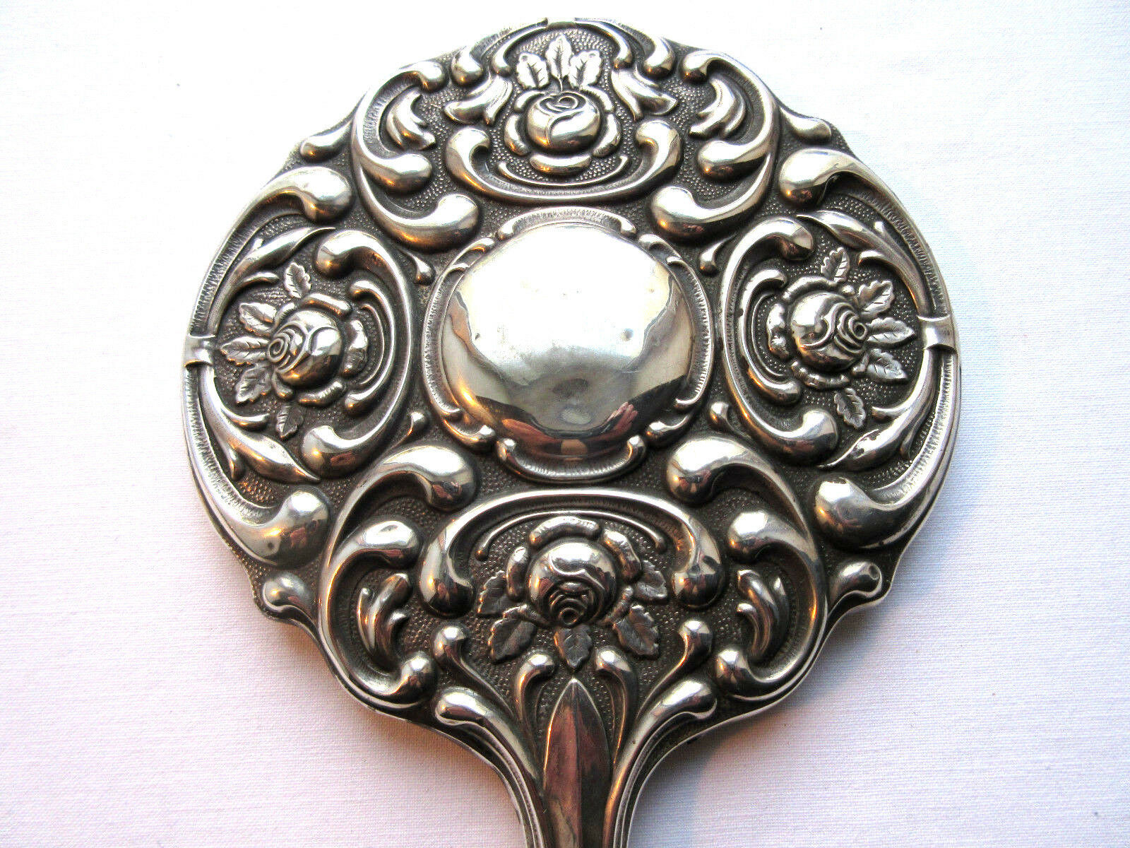 Art Nouveau hand-facing, mirror in repulsed silver frame, rose decoration 14x27cm