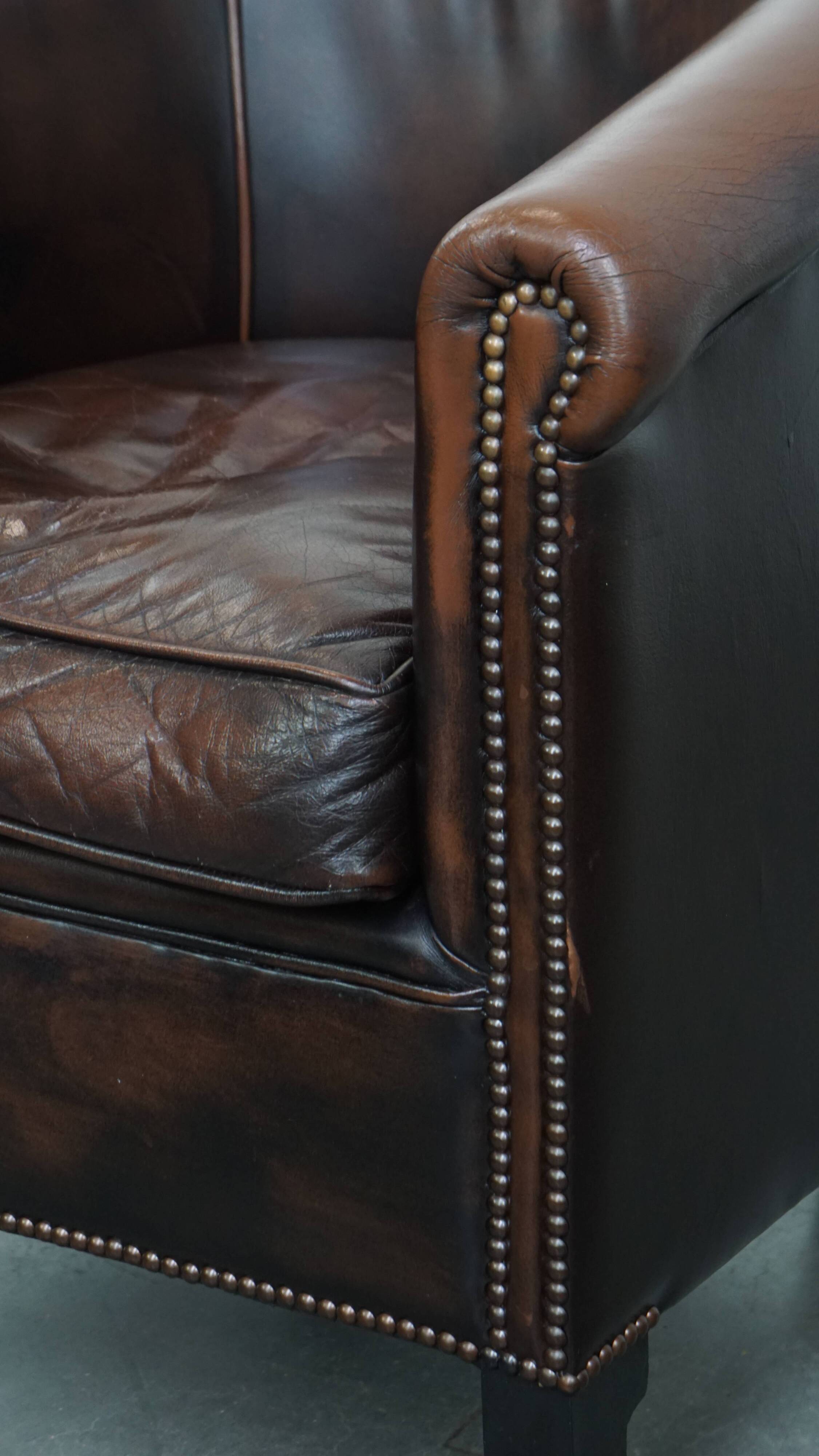Fauteuil club de couleur foncée en cuir de vachette
