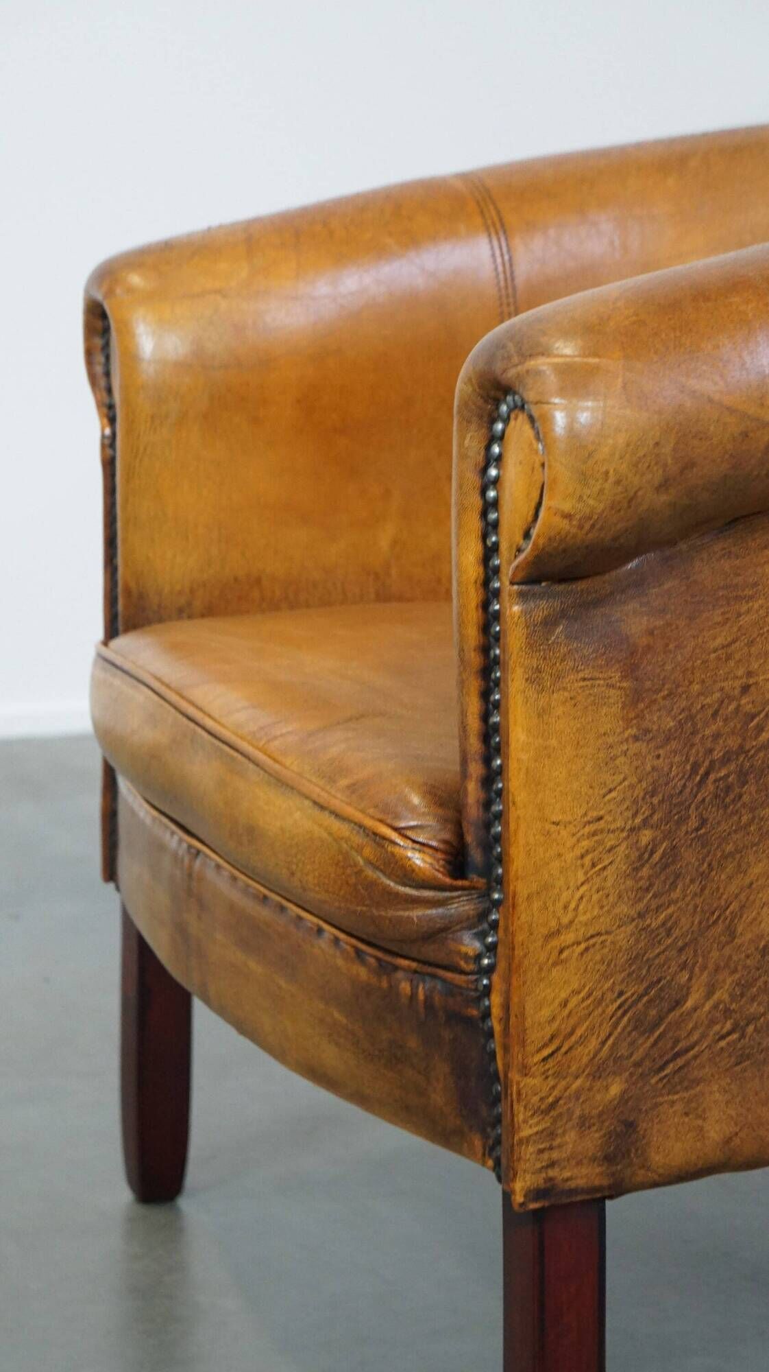 Fauteuil club en peau de mouton subtile avec finition cloutée décorative