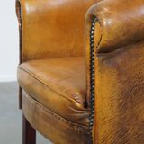 Subtle sheepskin club chair finished with decorative studs