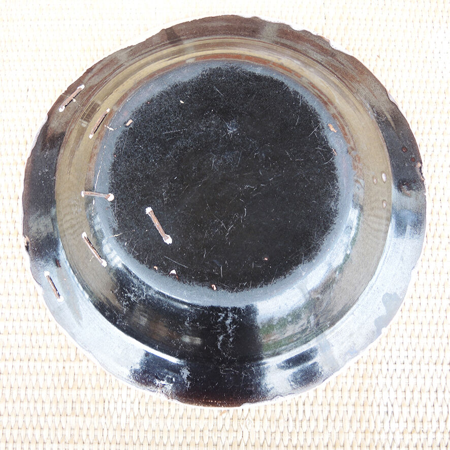 Old large round black ceramic dish