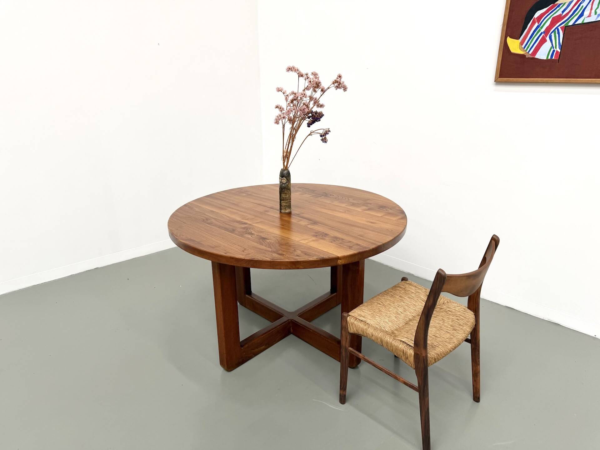 Modernist round table in solid elm, crossed legs.