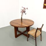 Modernist round table in solid elm, crossed legs.
