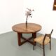 Modernist round table in solid elm, crossed legs.