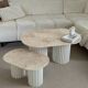 Oval coffee table duo travertine and white fluted wooden legs.