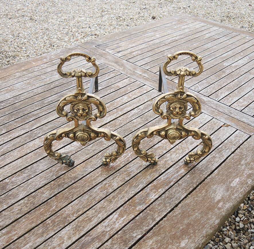 Antique brass andirons with lion decoration