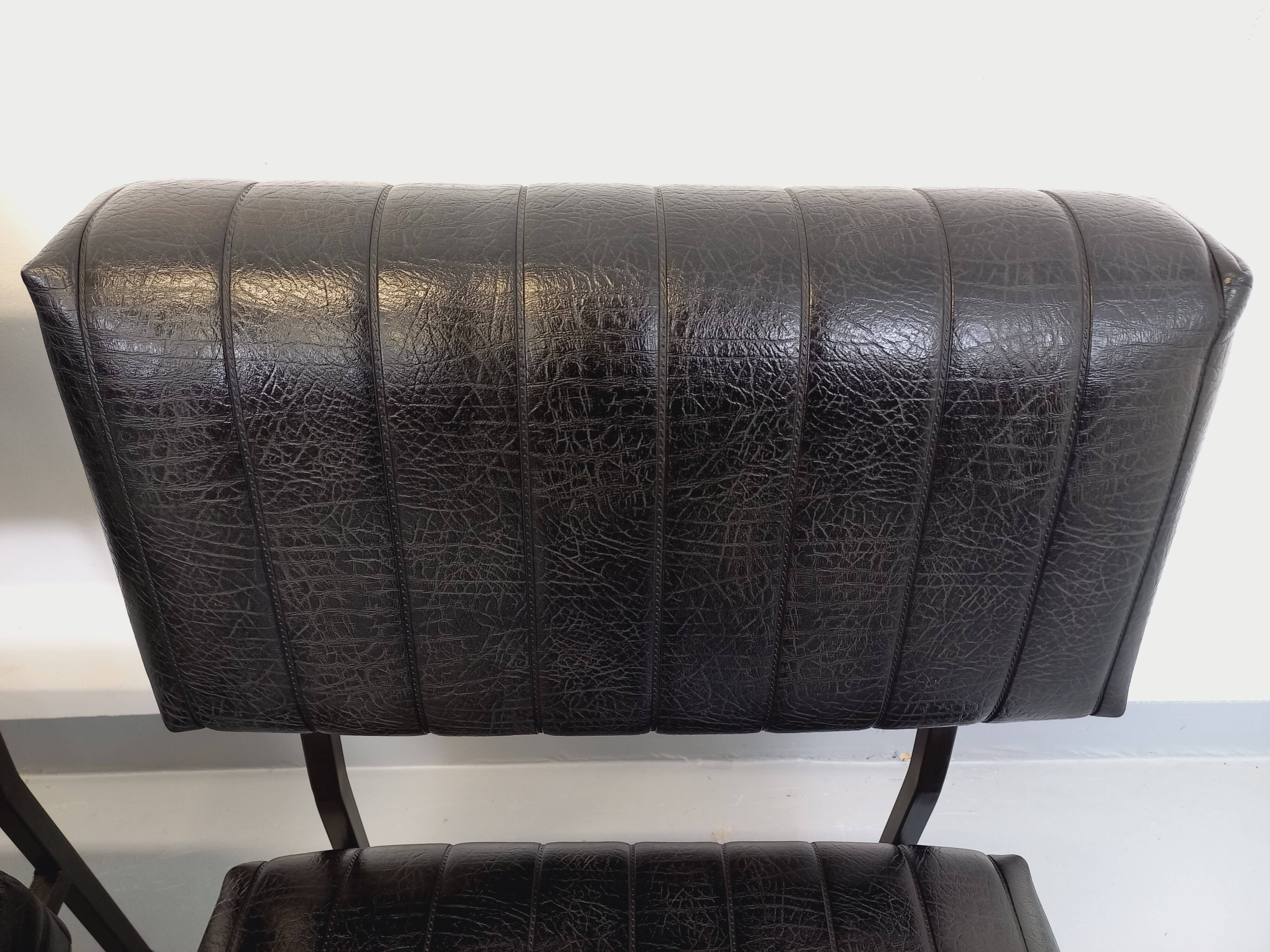 Set of 2 vintage modernist armchairs in black faux leather and metal.