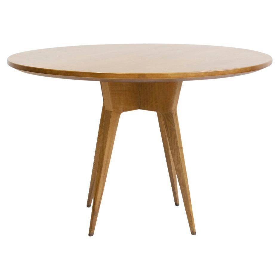 Round dining table in Wood Wood with brass details.