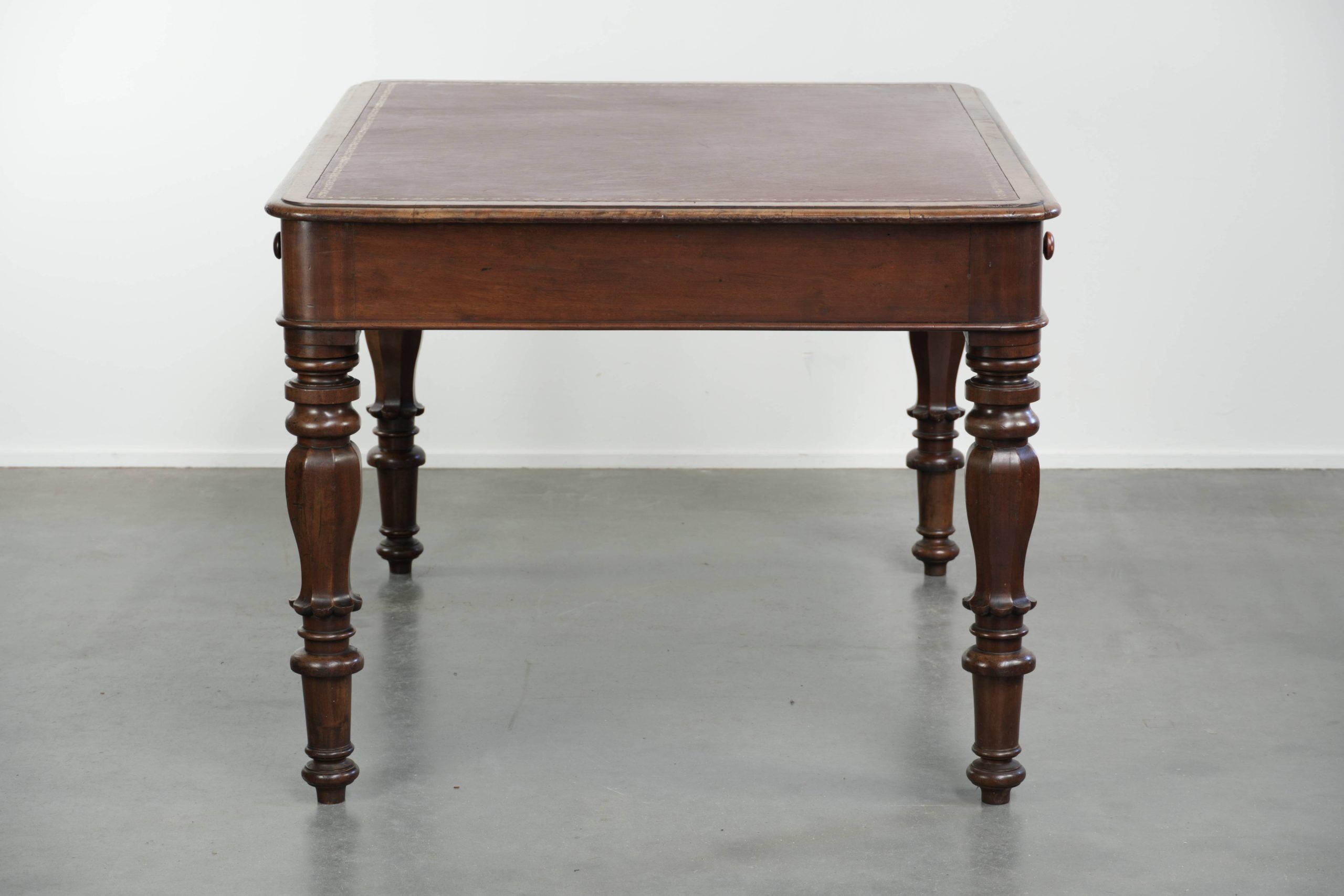 Antique English writing desk from the 19th century with a red leather top