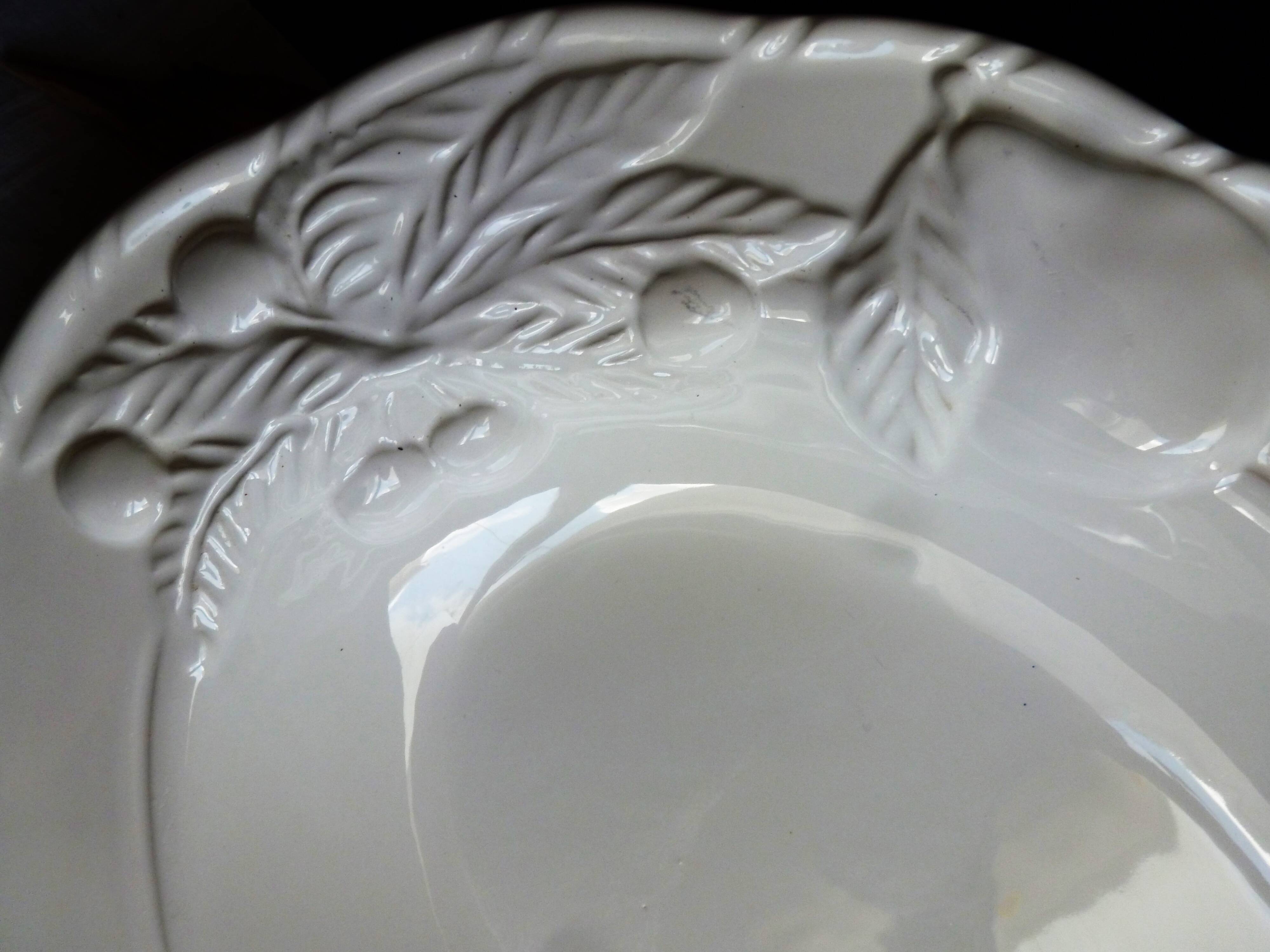 Oval white vegetable dish, an antique tableware piece in barbotine earthenware.