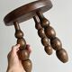 Small three-legged stool made of turned wood.