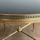 Round coffee table in brass with a black lacquered glass top from Maison Jansen.