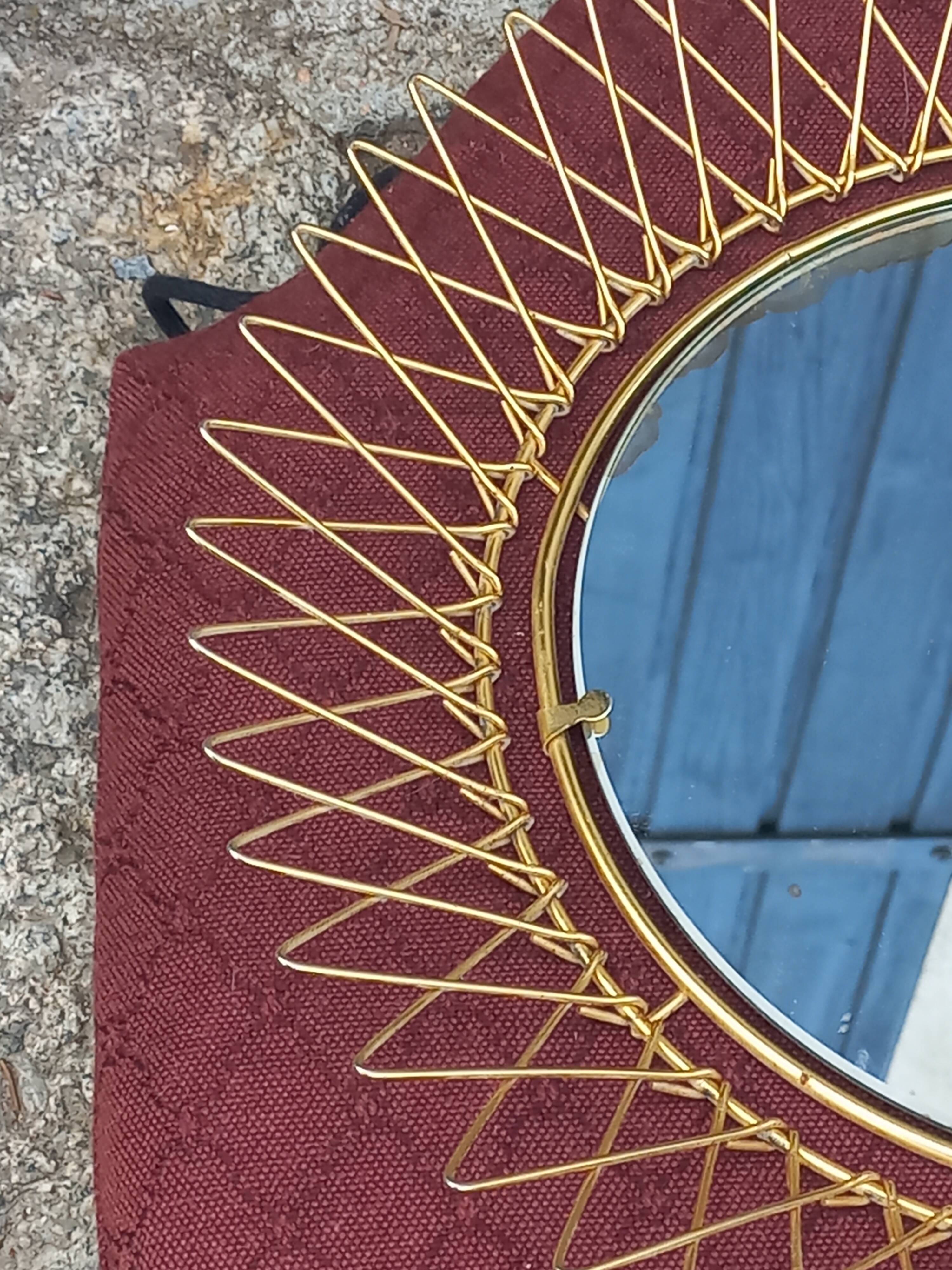 Vintage 1950s sun mirror in gold metal.