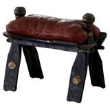 Dark red upholstered camel saddle stool, 20th century, North Africa.