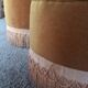 False pair of round Napoleon III poufs in ochre velvet, tufted with fringes.