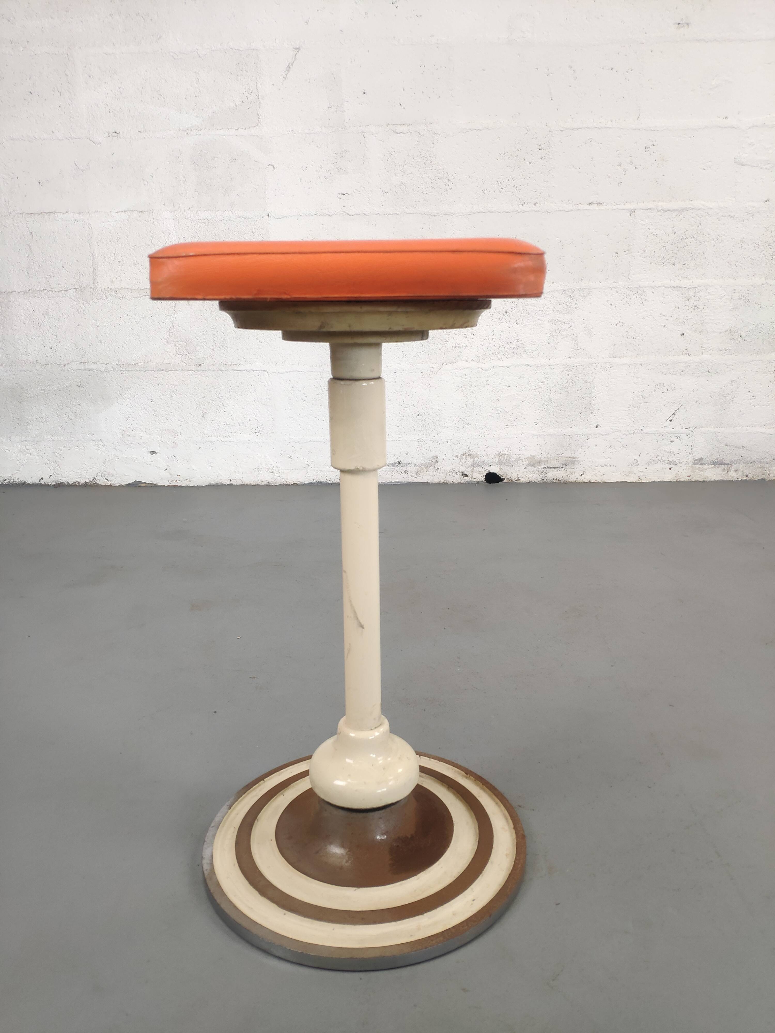 Old swivel orange sitting dentist stool