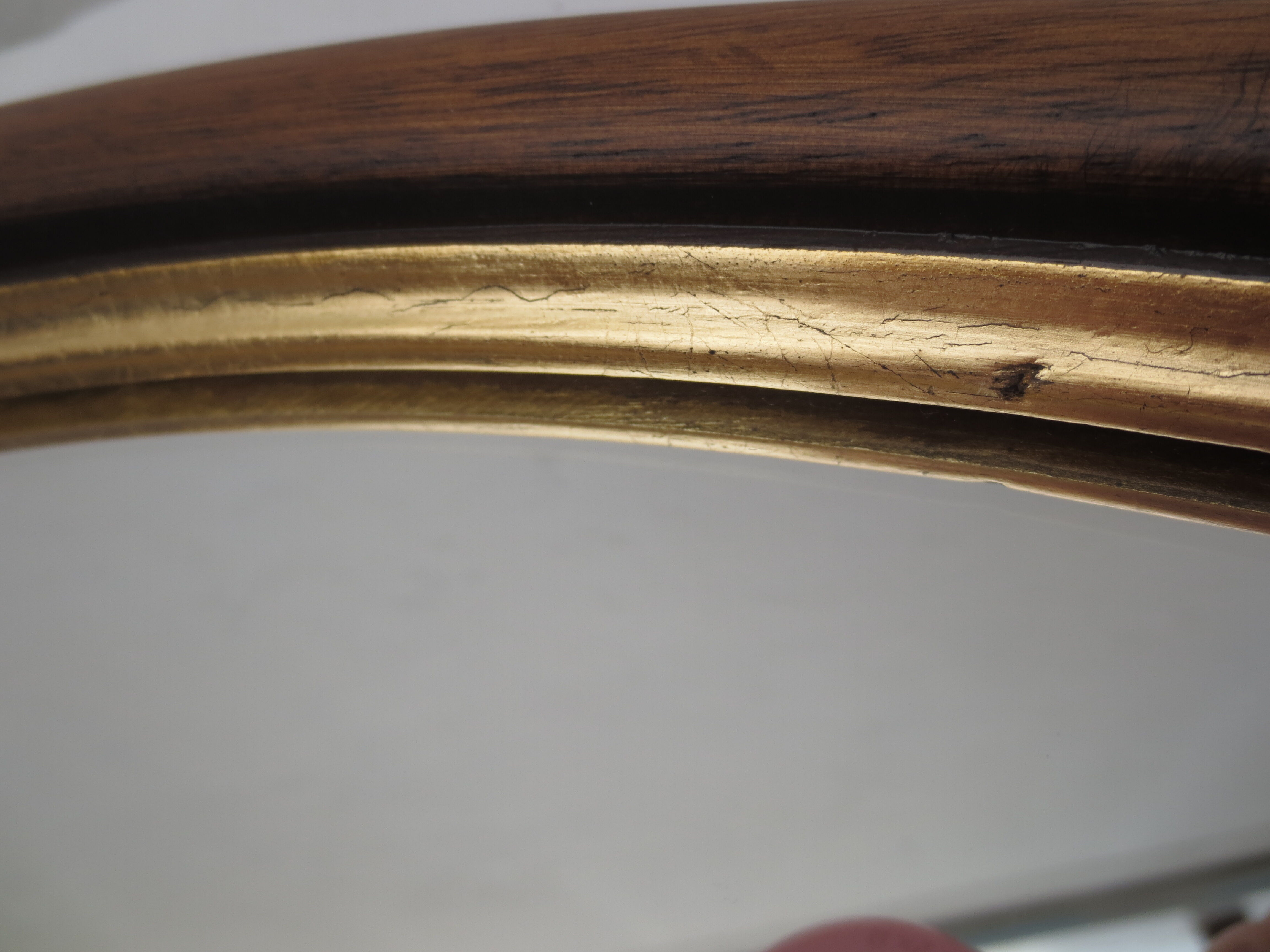 Old oval mirror, walnut wood tower, gilded border