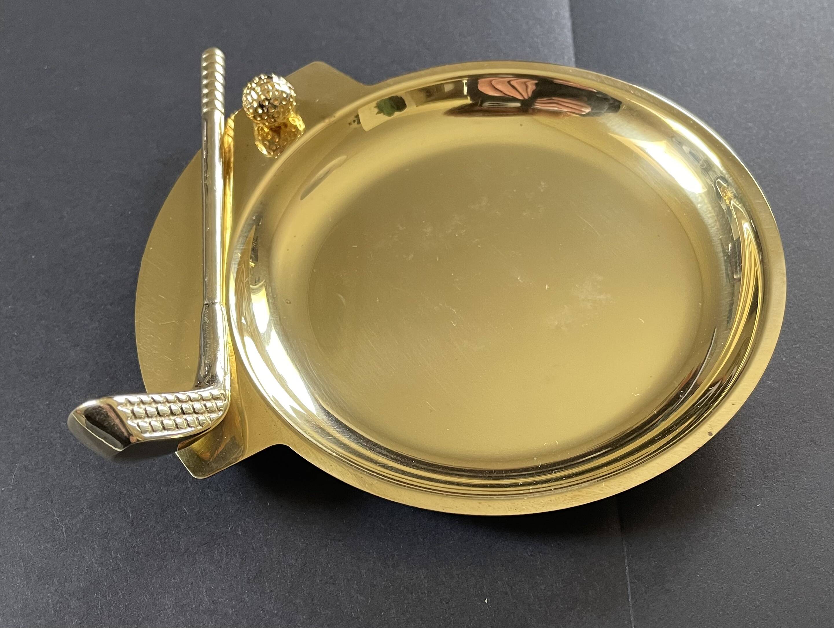 Round brass pocket tray with club and golf ball decoration.