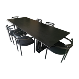Table de salle à manger noire, en bois, rectangle avec chaises rembourrées.