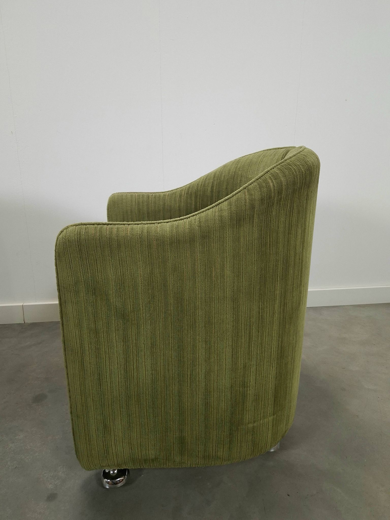 Chaises de cocktail vertes avec des roues chromées.