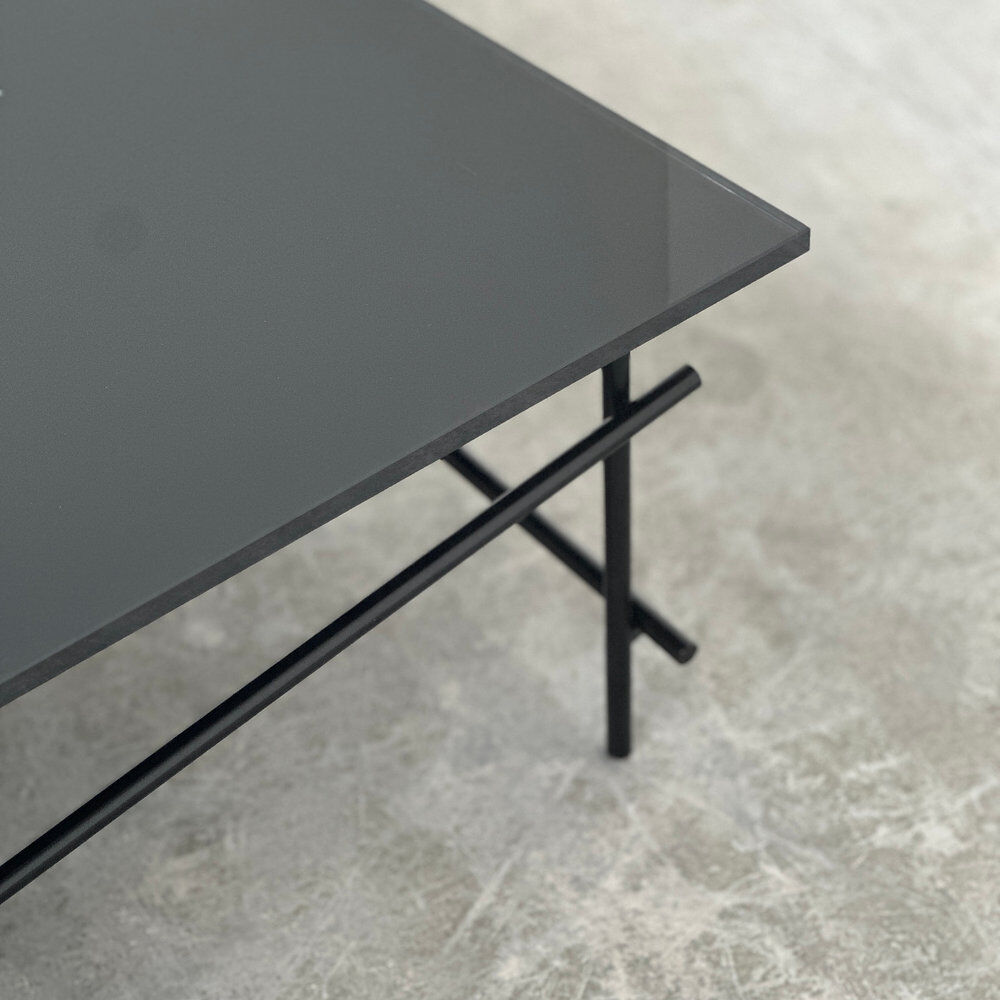 Minimalist black glass coffee table with industrial metal base