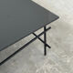 Minimalist black glass coffee table with industrial metal base