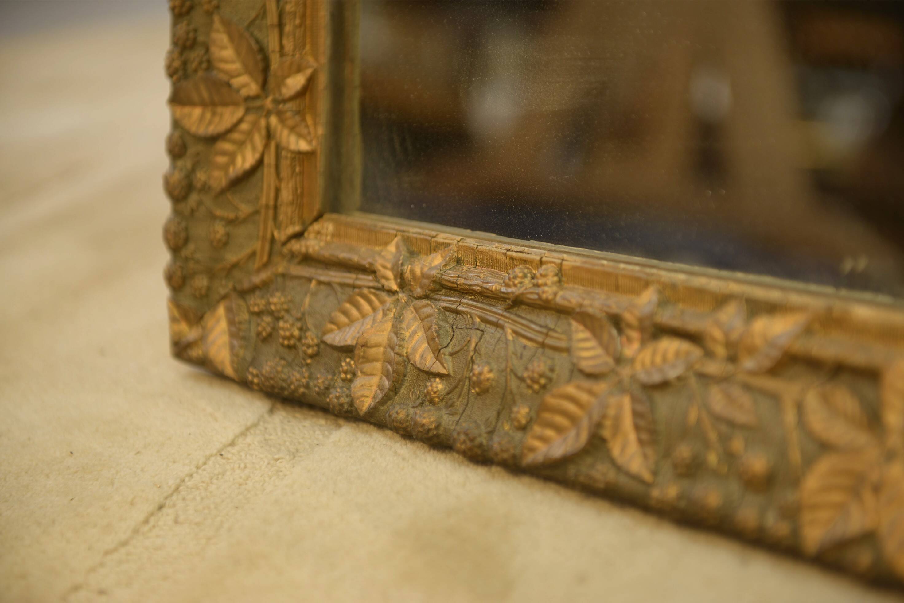 19th-century mirror in wood and stucco with floral decoration.