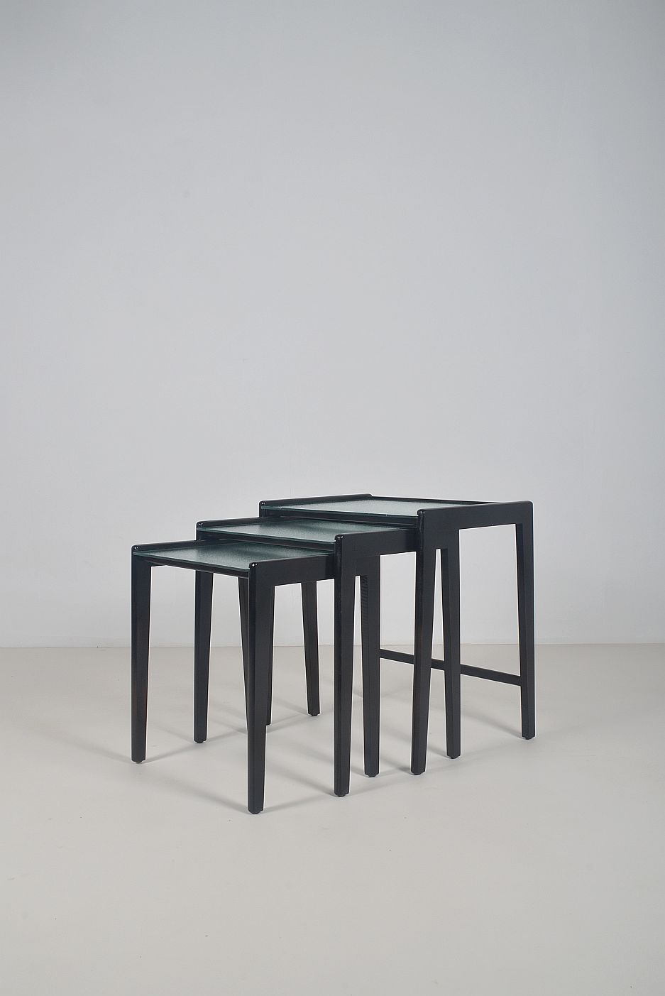 Tables gigognes en bois teinté noir et plateau en verre, années 1960