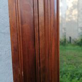 Old beveled solid wood mirror of a cabinet door.
