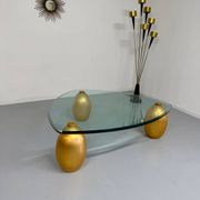 Vintage Italian design coffee table with a glass top and gold base, dating from the 1980s.