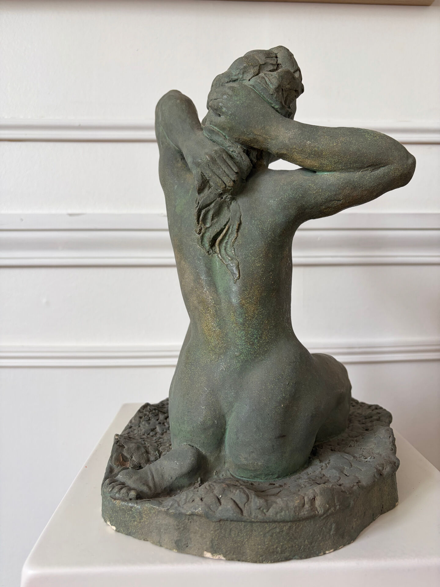 Sculpture of a naked woman titled "Youth" in terracotta.