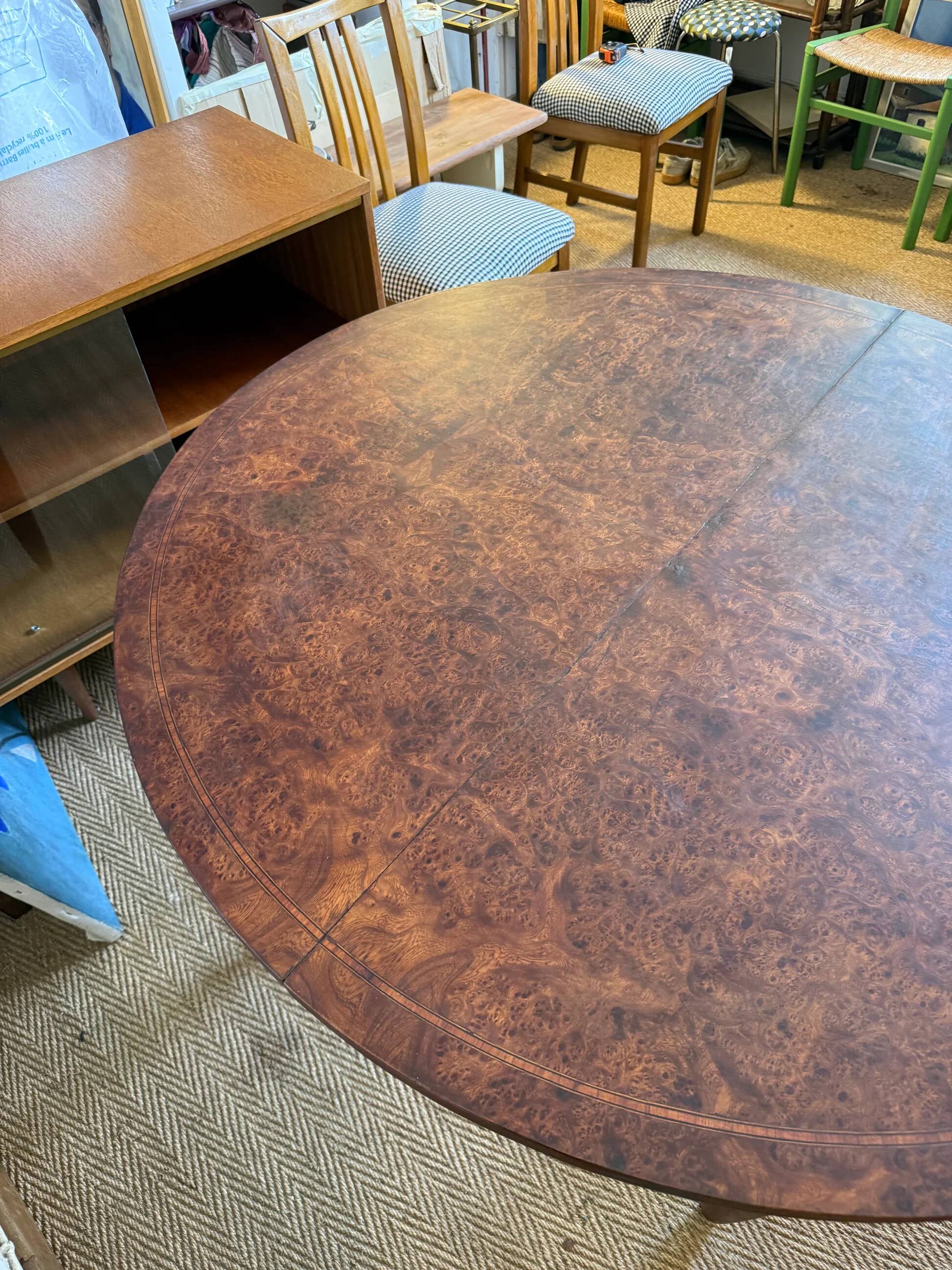 Oval extendable dining table in wood and walnut burl veneer.
