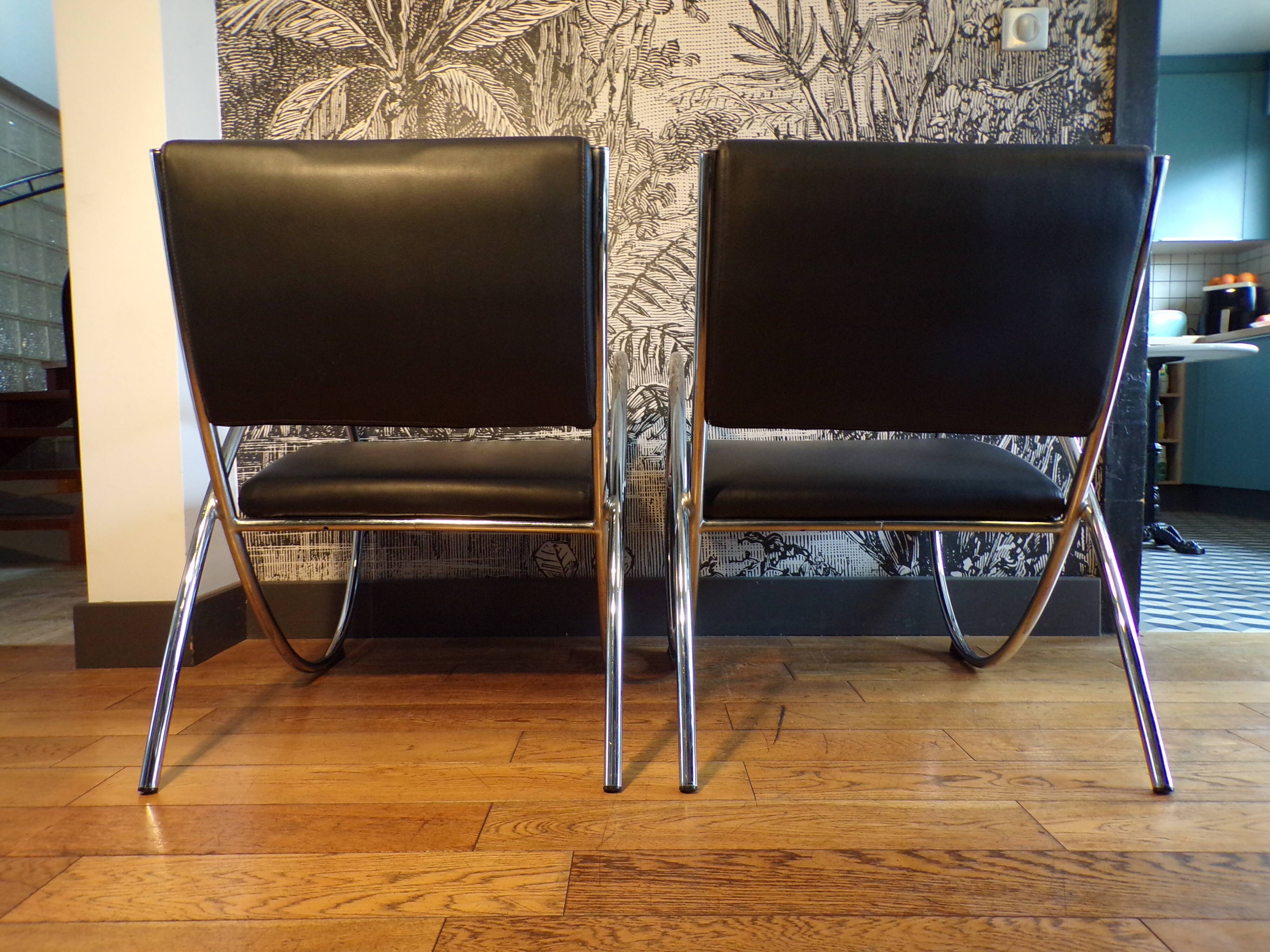 Pair of chrome and faux leather armchairs