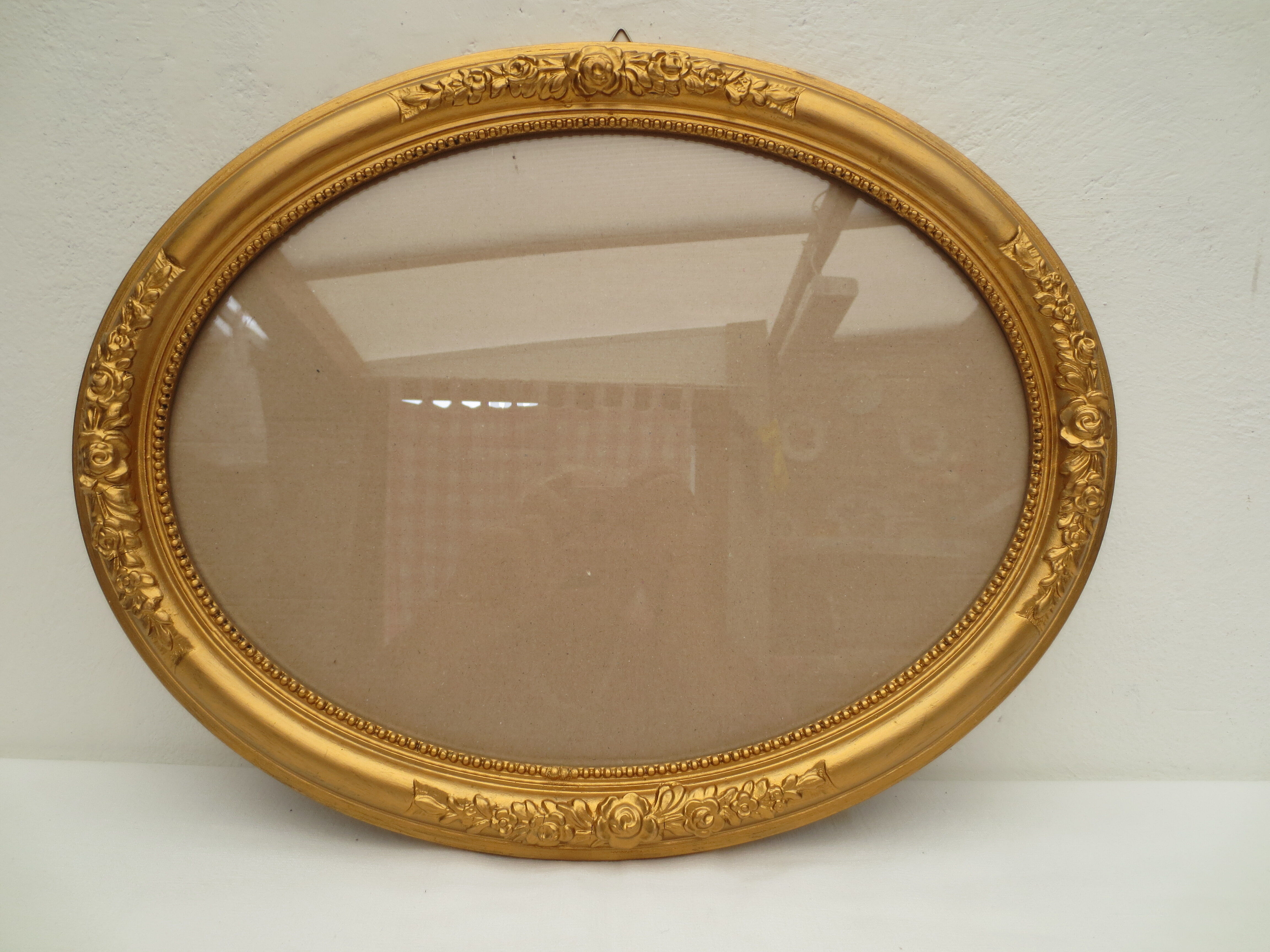 Large old oval gilded wooden frame and stucco decorations