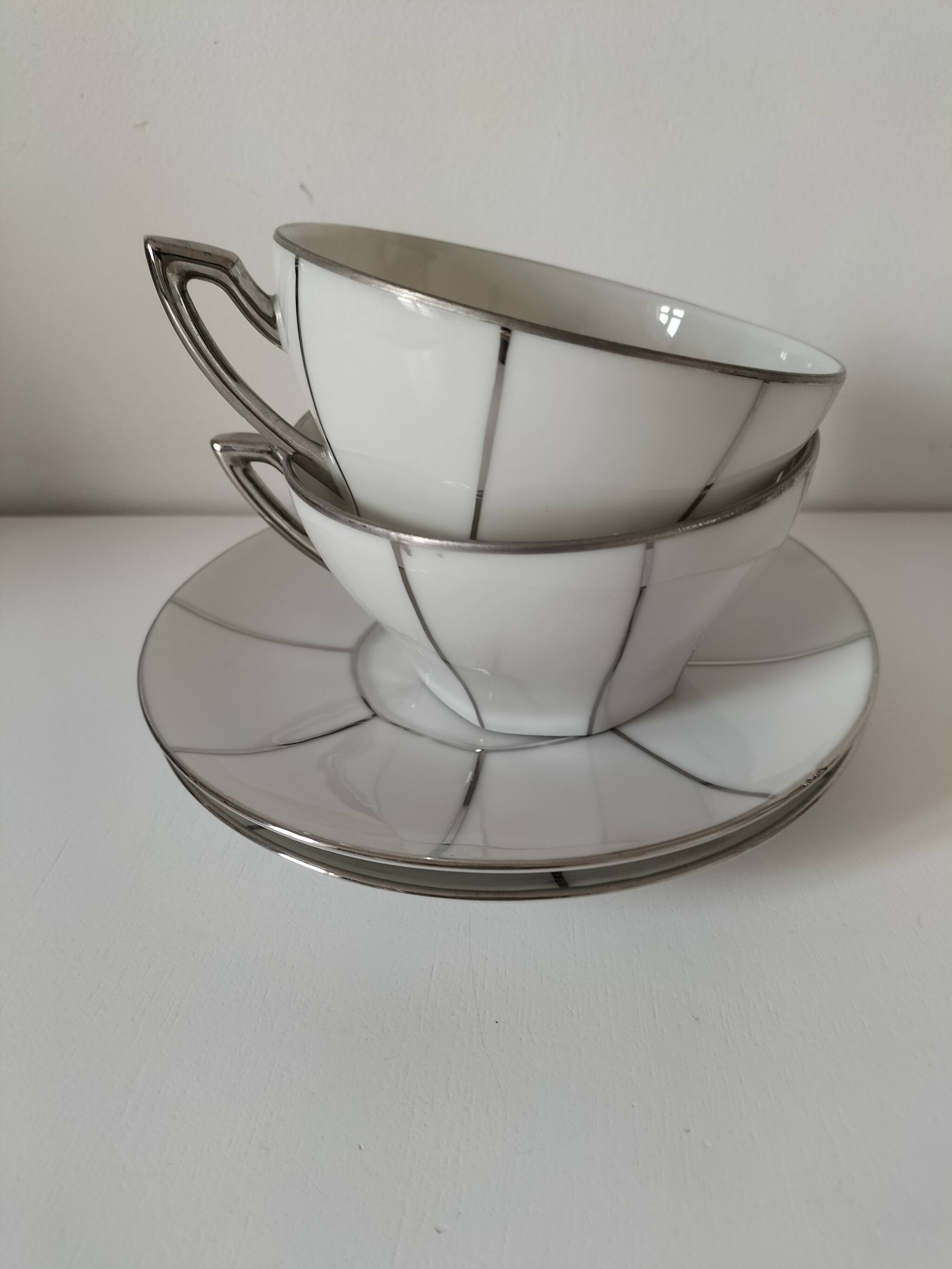 Two Art Deco porcelain cups and saucers with silver trim.