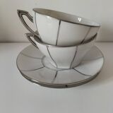 Two Art Deco porcelain cups and saucers with silver trim.